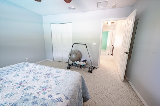 carpeted bedroom with ceiling fan and a closet