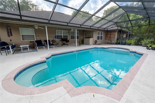 view of swimming pool with ceiling fan, a lanai, and a patio