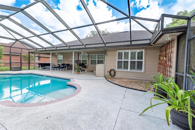 view of pool with a patio area and glass enclosure