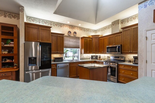 kitchen with sink, backsplash, a center island, and stainless steel appliances