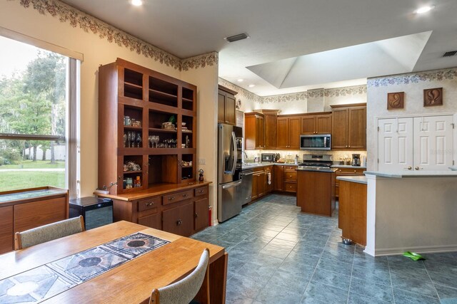 kitchen featuring stainless steel appliances, decorative backsplash, and a center island