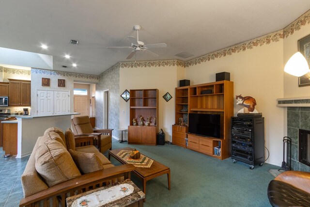 living room with ceiling fan and a tile fireplace