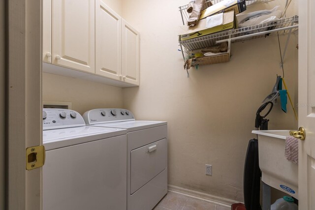 washroom featuring light tile patterned floors, separate washer and dryer, and cabinets