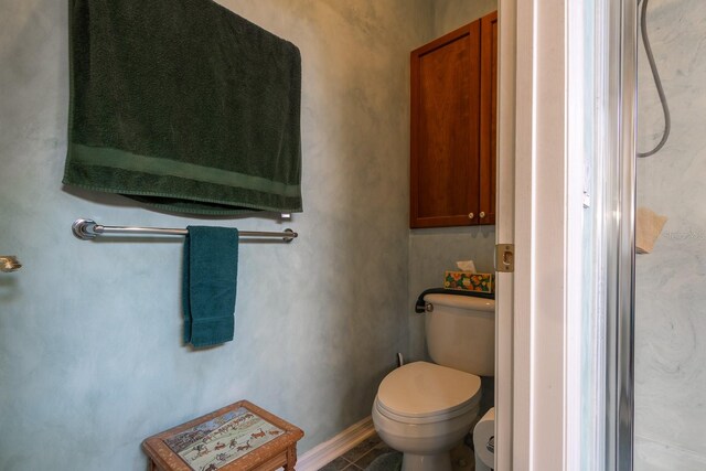 bathroom with toilet and tile patterned floors