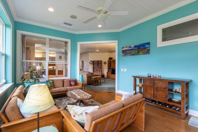 living room featuring hardwood / wood-style flooring, ornamental molding, and ceiling fan