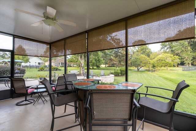 sunroom / solarium featuring ceiling fan