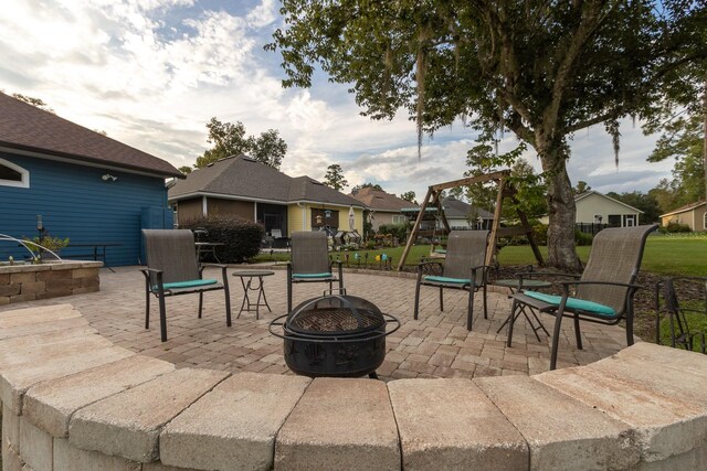 view of patio / terrace with a playground and an outdoor fire pit