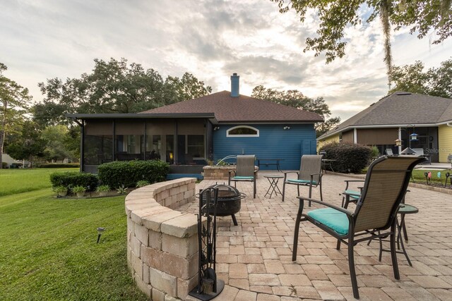 view of patio with a sunroom and a fire pit