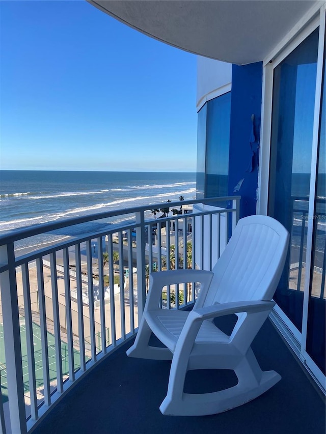 balcony featuring a view of the beach and a water view