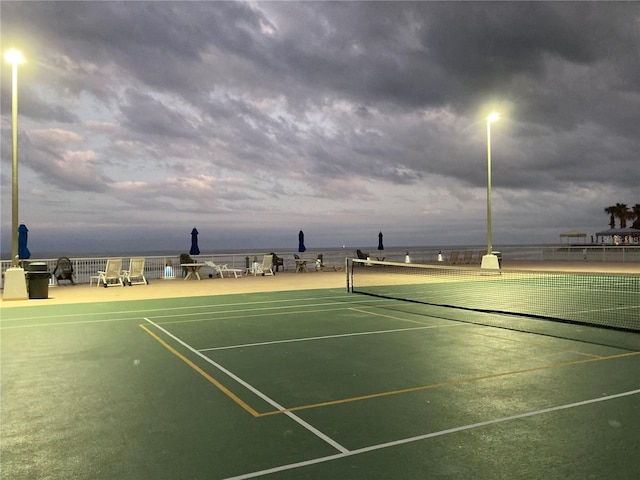 view of tennis court with a water view