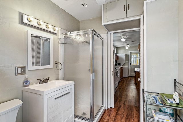 bathroom featuring ceiling fan, hardwood / wood-style flooring, a shower with door, and vanity