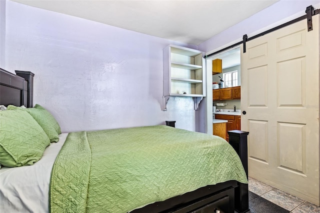 bedroom with a barn door and a sink