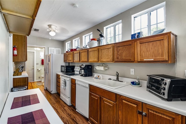 kitchen with white appliances, visible vents, a sink, and a healthy amount of sunlight