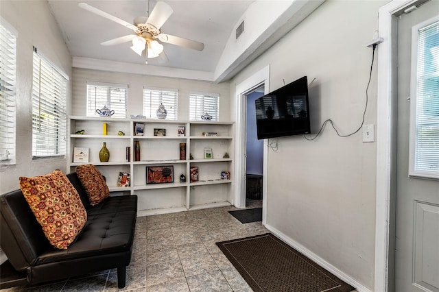 living area with baseboards, visible vents, and a ceiling fan