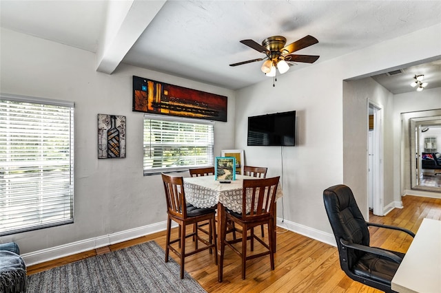 dining room featuring ceiling fan, baseboards, wood finished floors, and beamed ceiling