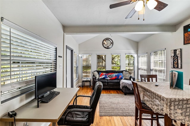 home office featuring lofted ceiling with beams, ceiling fan, a wealth of natural light, and light wood-style flooring