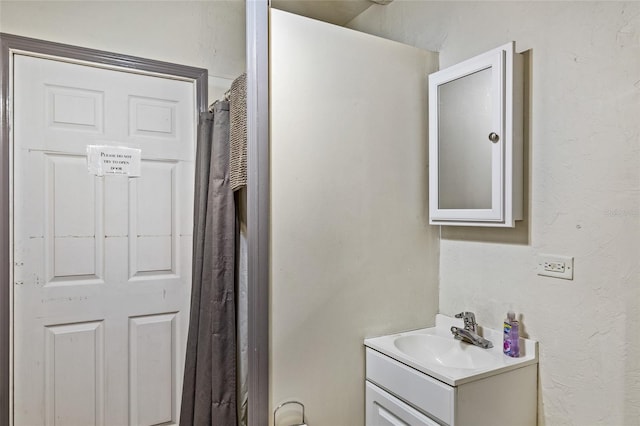 bathroom with a textured wall and vanity