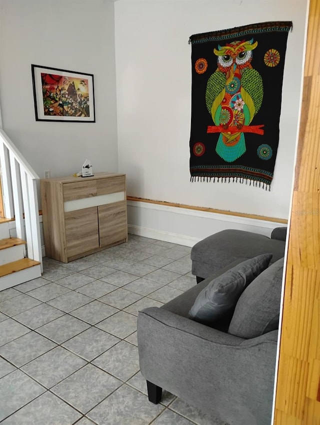 living area with baseboards and tile patterned floors