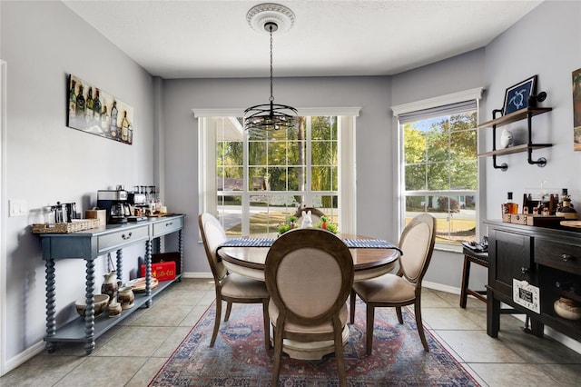 dining area with a chandelier and light tile patterned flooring