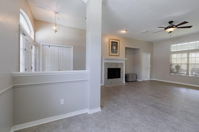 unfurnished living room featuring carpet flooring, a tile fireplace, and ceiling fan