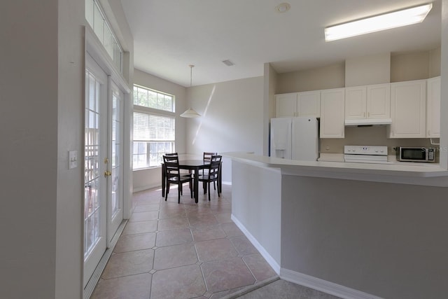 kitchen with white cabinetry, white refrigerator with ice dispenser, stove, pendant lighting, and light tile patterned flooring