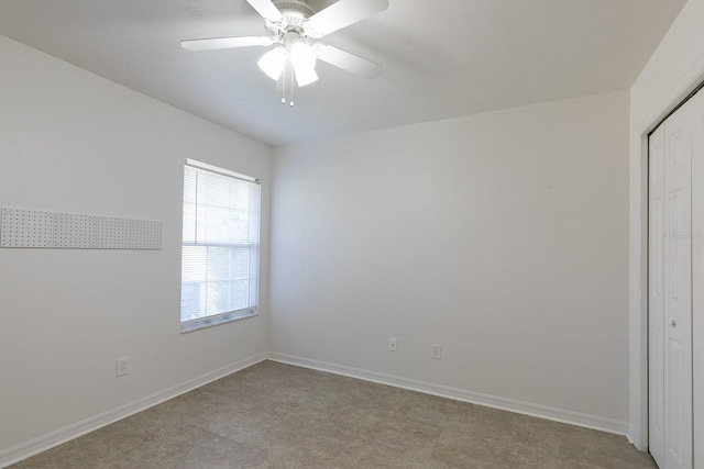 carpeted spare room with ceiling fan