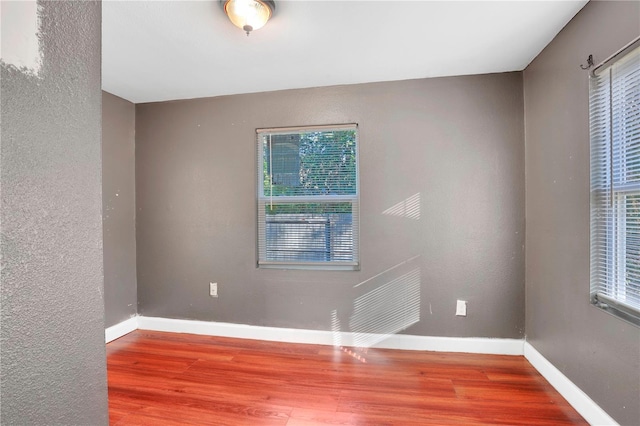 unfurnished room with hardwood / wood-style flooring