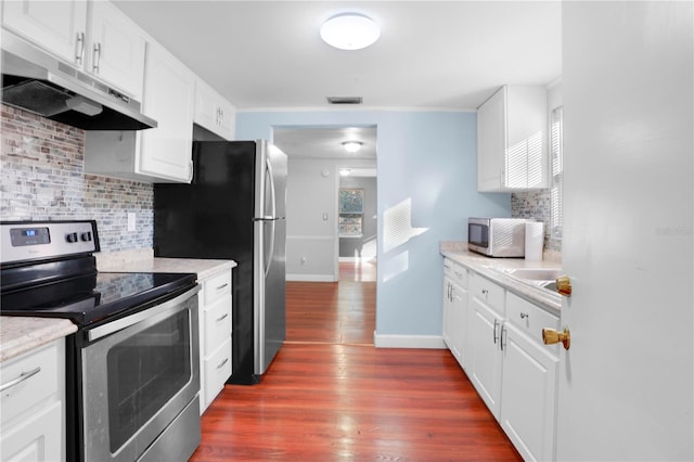 kitchen with decorative backsplash, appliances with stainless steel finishes, white cabinetry, and dark wood-type flooring