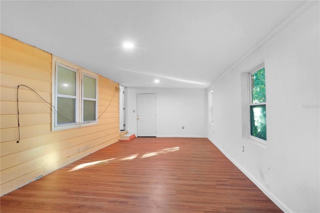 spare room with ornamental molding, hardwood / wood-style flooring, and wooden walls