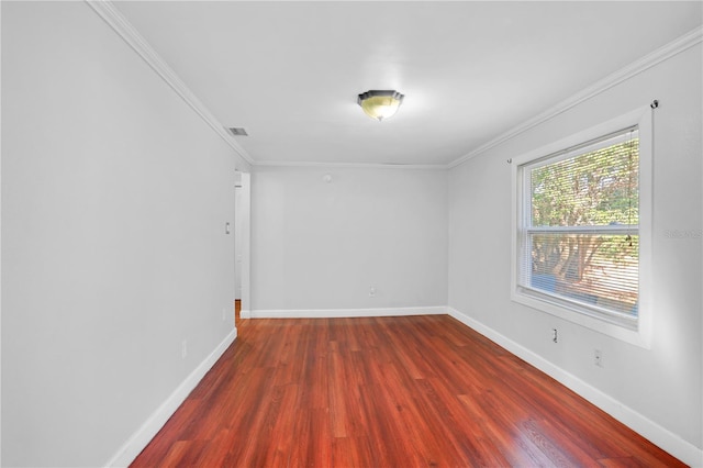 spare room featuring dark hardwood / wood-style flooring and crown molding