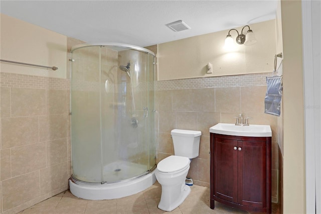 bathroom with toilet, vanity, tile walls, and walk in shower