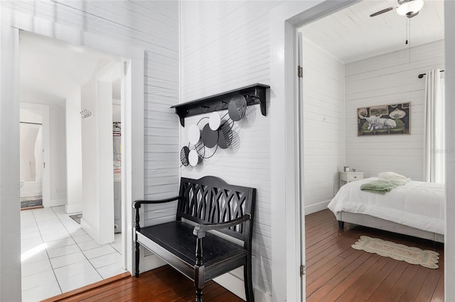 bedroom featuring wood-type flooring, ceiling fan, and ensuite bath