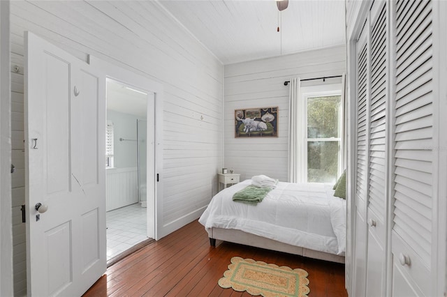 bedroom with ensuite bathroom and dark hardwood / wood-style floors