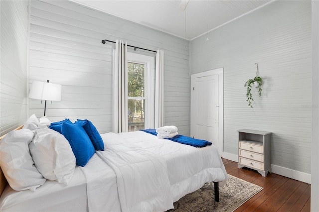 bedroom with dark hardwood / wood-style flooring