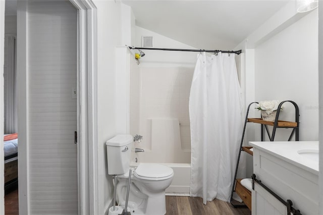 full bathroom with toilet, vaulted ceiling, vanity, shower / bath combo with shower curtain, and hardwood / wood-style floors