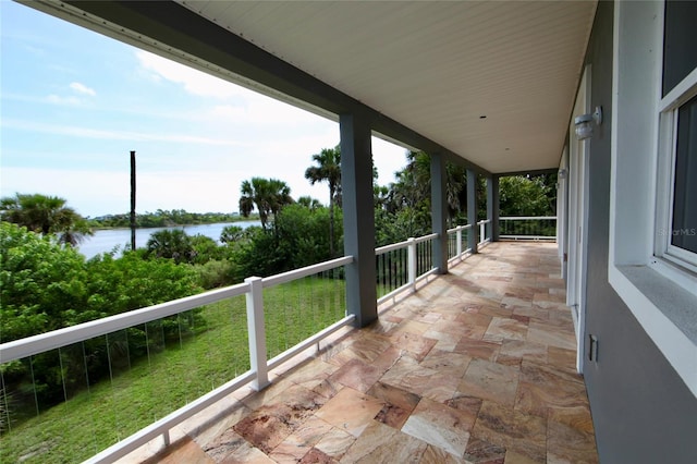 view of patio with a balcony and a water view