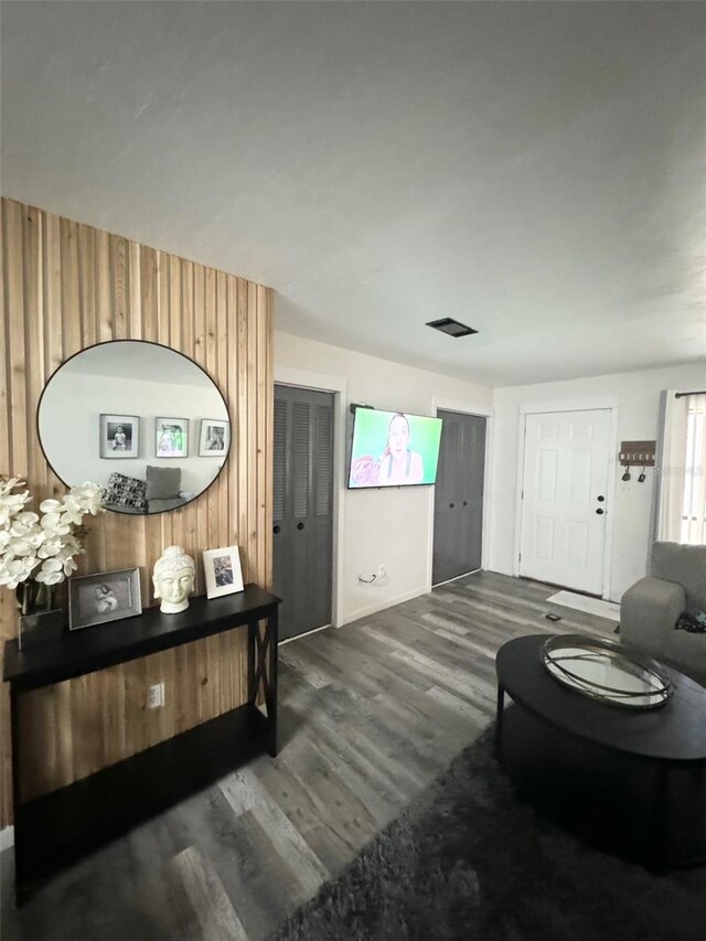 interior space featuring dark wood-type flooring and wood walls