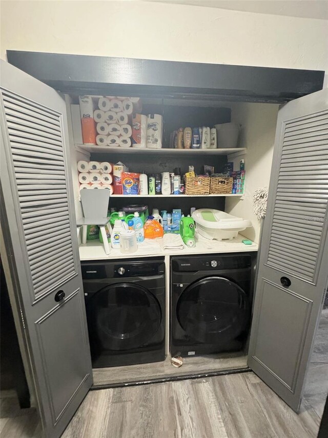 laundry room with light hardwood / wood-style floors and washer and clothes dryer