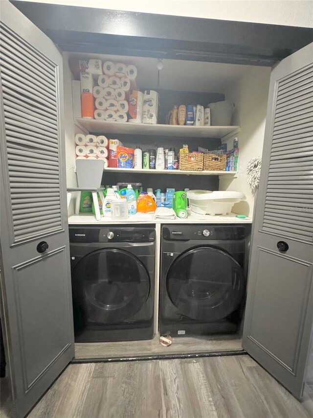 laundry area featuring light hardwood / wood-style flooring and washing machine and dryer