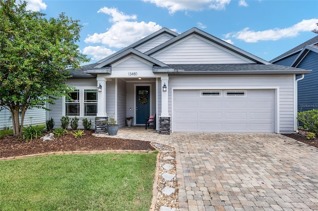 view of front of house featuring a garage and a front lawn