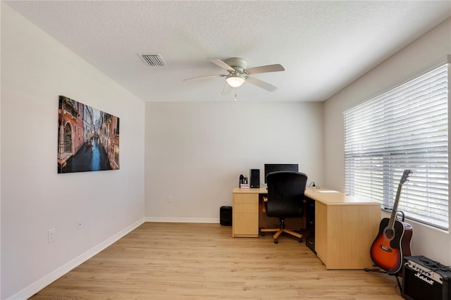 office area with ceiling fan, a textured ceiling, plenty of natural light, and light hardwood / wood-style floors