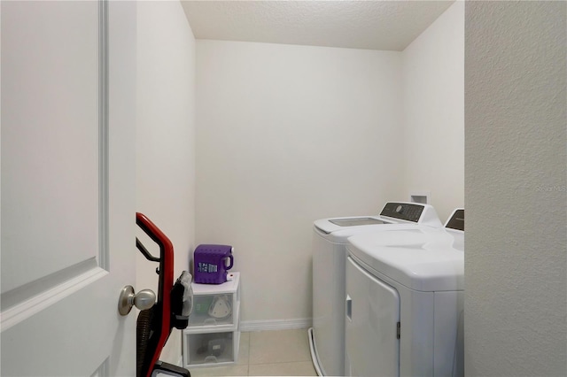 clothes washing area featuring a textured ceiling, independent washer and dryer, and light tile patterned flooring