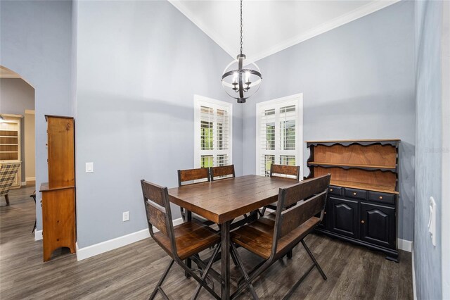 dining area featuring ornamental molding, dark hardwood / wood-style flooring, high vaulted ceiling, and an inviting chandelier