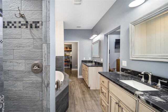 bathroom featuring vanity, wood-type flooring, and plus walk in shower