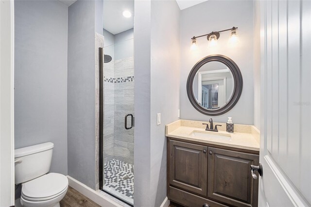 bathroom with walk in shower, toilet, wood-type flooring, and vanity