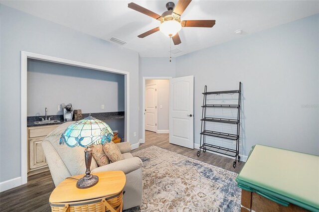 living room featuring ceiling fan, sink, and hardwood / wood-style floors