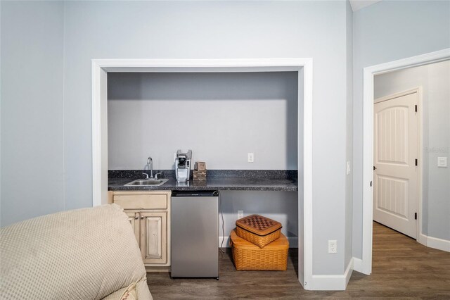 bedroom with indoor wet bar and dark hardwood / wood-style floors