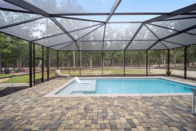 view of swimming pool with glass enclosure, a patio, and a hot tub