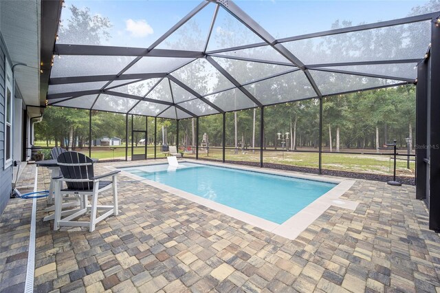 view of pool featuring a lawn, a lanai, and a patio