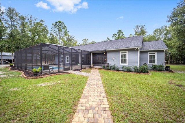 view of front of property with glass enclosure and a front yard